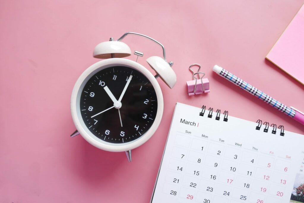 Foto ilustrativa do texto Ciclo circadiano para o blog da Arimo. Na foto, um relógio despertador e um calendário.